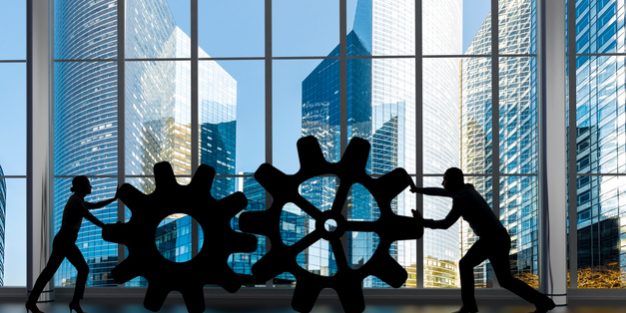 Business collaboration concept Silhouettes of business partners moving gears inside an office