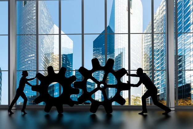 Business collaboration concept Silhouettes of business partners moving gears inside an office